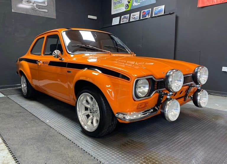 Restored orange classic Ford Escort with spotlights
